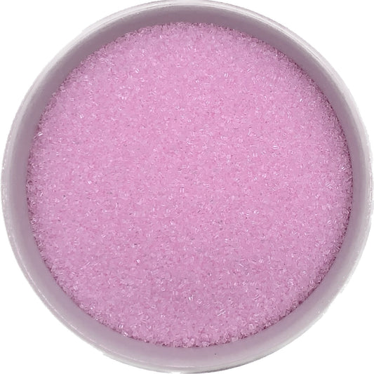 Pastel pink sanding sugar in a clear container, vibrant crystals perfect for birthday and Valentine’s bakes.