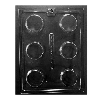 Clear six-cavity chocolate mold on a dark background, each cavity forming a thick, smooth-faced round disc about 2.25" wide x 0.75" deep; decorate-forward cookie mold.