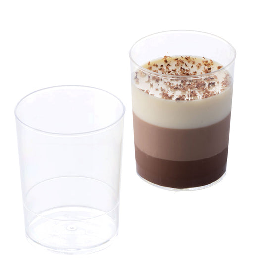 Two clear plastic dessert cups, one empty and one filled with layered chocolate dessert in dark, milk, and white layers topped with chocolate shavings.