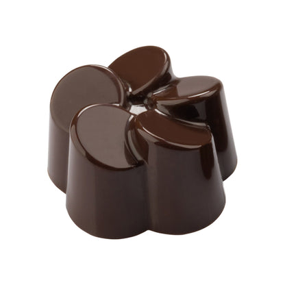 Shiny dark chocolate bonbon shaped like a stylized flower with rounded petals and a glossy finish on a white background.