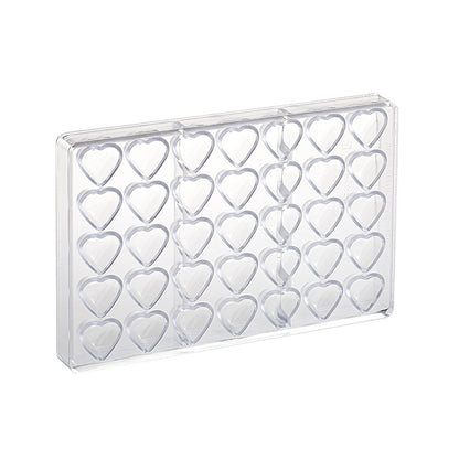 Clear polycarbonate chocolate mold with multiple small heart-shaped cavities arranged in rows, shown on a white background.