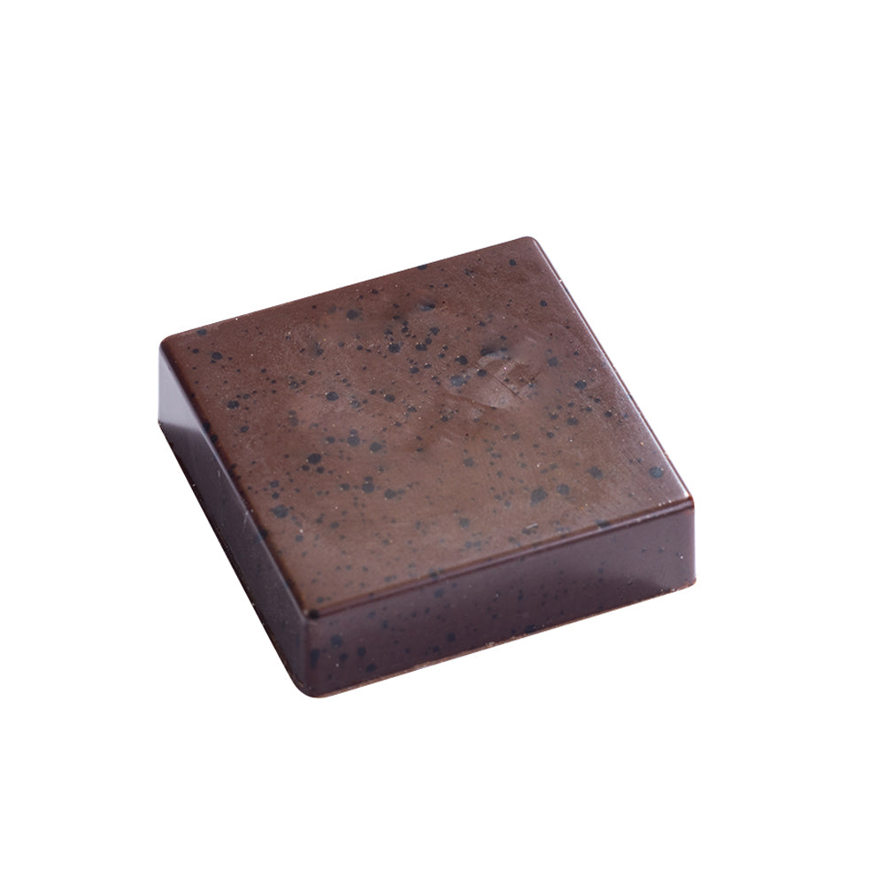 Single bite-size square chocolate with a glossy dark finish and speckled cocoa butter effect on top, shown on a white background.