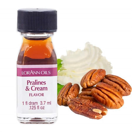Small bottle of LorAnn Oils Pralines & Cream flavoring with a black cap and white label, shown alongside whipped cream and whole pecans on a white background.