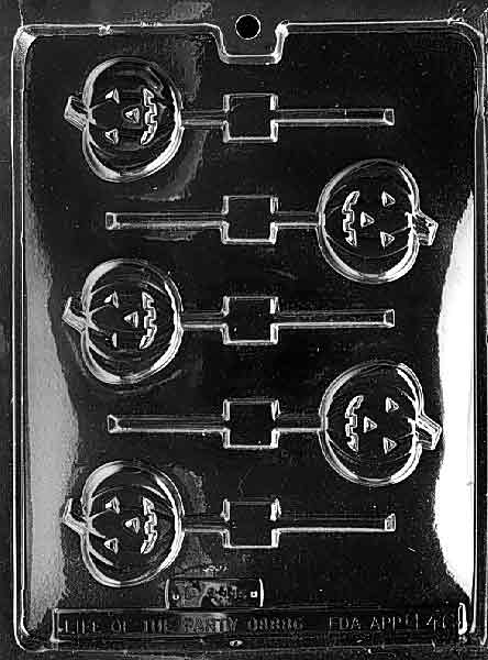 Clear lollipop mold with four round jack-o’-lantern pumpkin cavities, each aligned to a stick channel, glossy plastic against a dark background.
