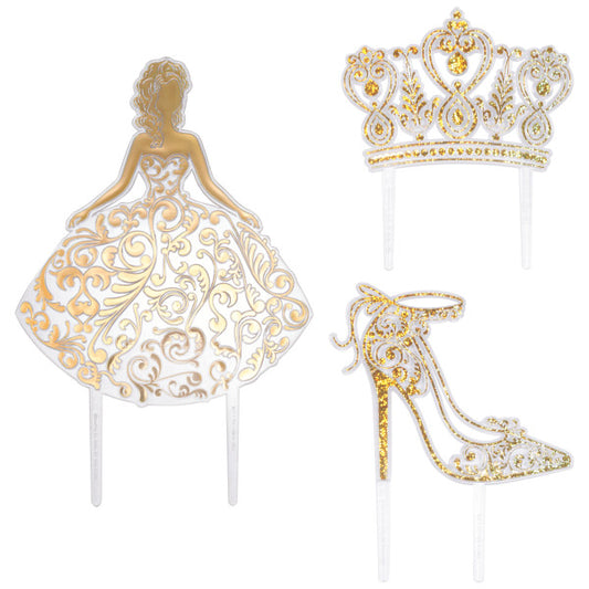 Three gold Quinceañera cake toppers including a girl in a gown, a crown, and a high heel with glittering details.