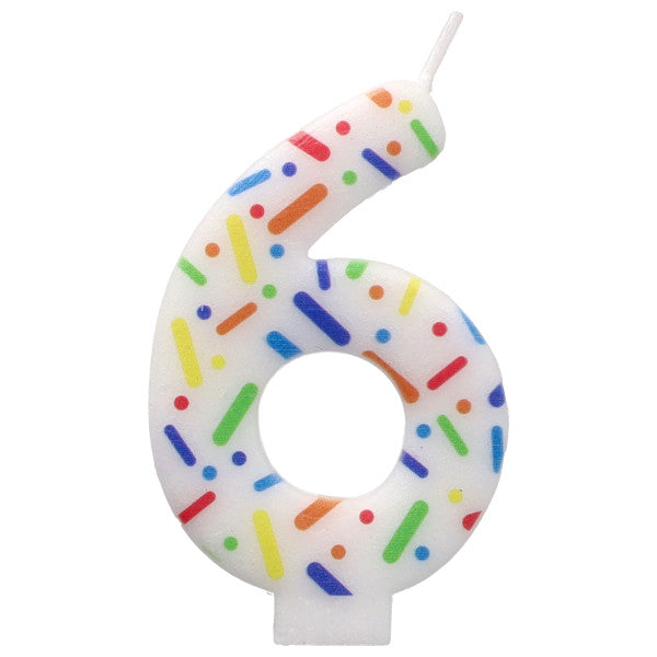 Candle shaped like the number 6 with colorful sprinkles on a white background