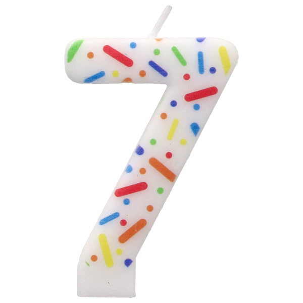 Number 7 birthday candle with colorful sprinkles on a white background