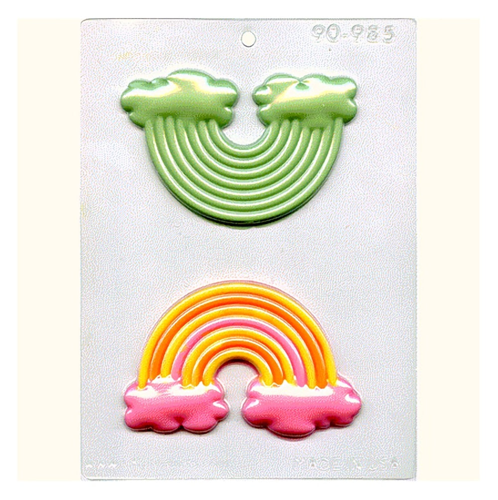 A Chocolate mold featuring 2 rainbow shaped cavities. These cavities are filled with colored chocolate to demonstrate how the mold can be used. 
