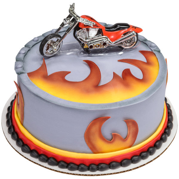 Round cake with grey icing, bold yellow-orange flames, and red chopper motorcycle topper.
