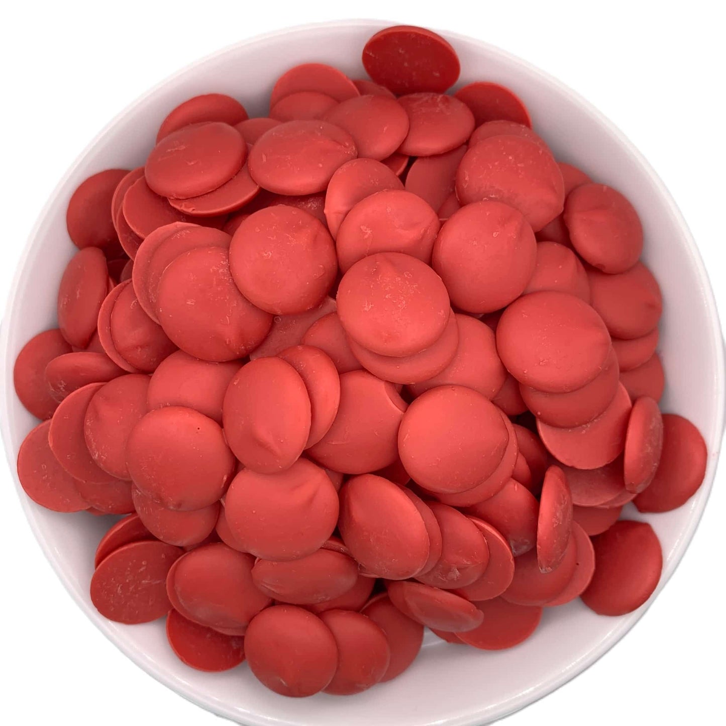Top view of Merckens red chocolate melting wafers, displaying vibrant red discs that offer a pop of color and sweet flavor to any chocolate craft.