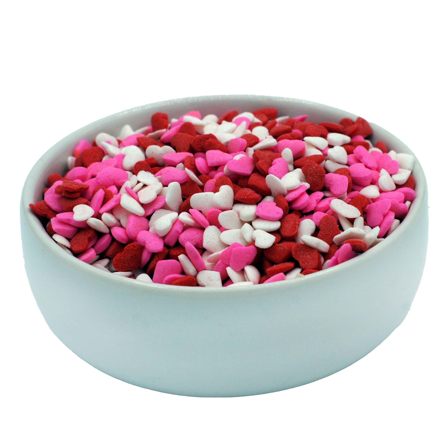 Close-up of mini heart sprinkles in red, white, and pink for decorating cupcakes and cookies.