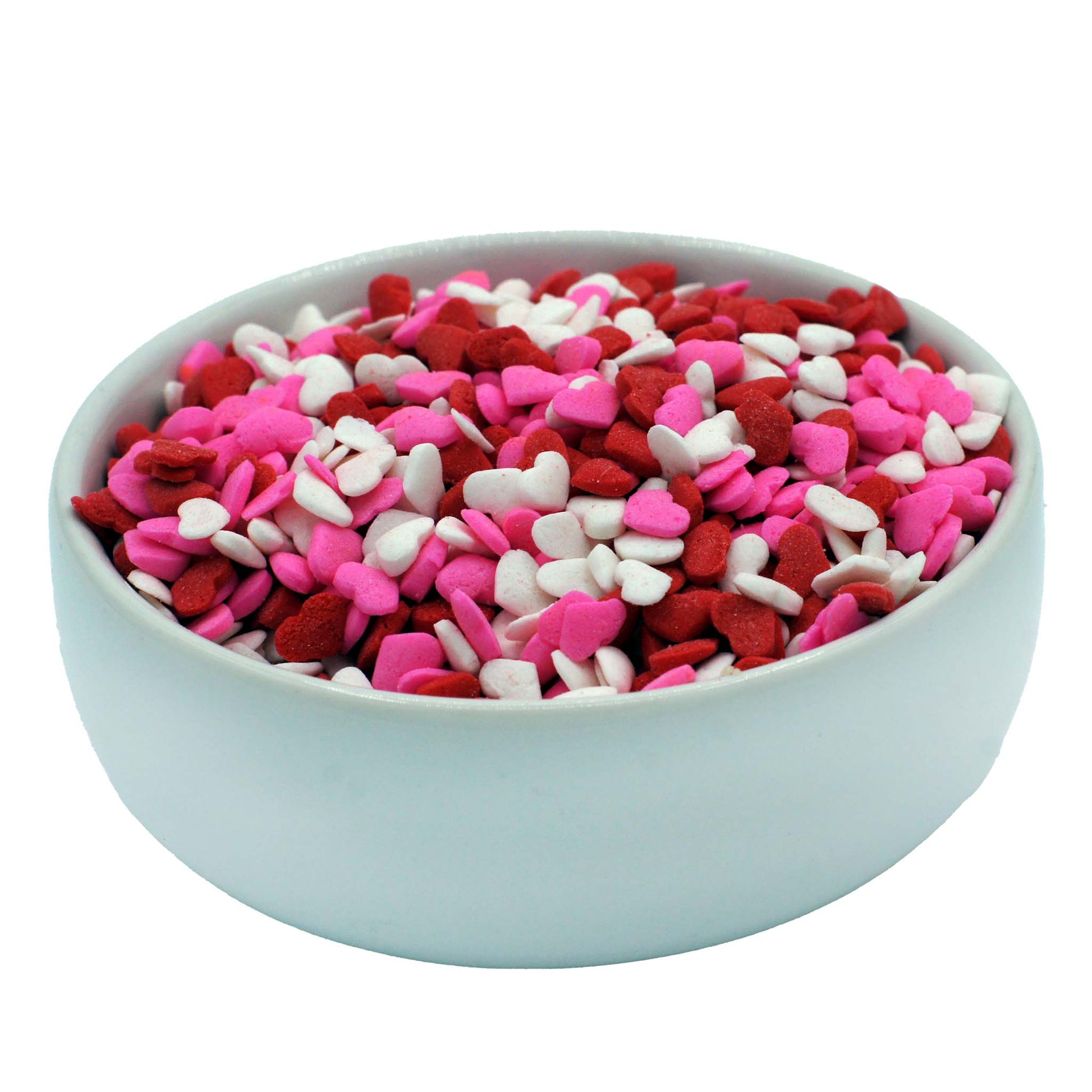 Close-up of mini heart sprinkles in red, white, and pink for decorating cupcakes and cookies.