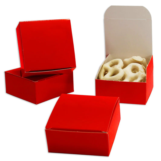 Red square candy boxes shown open and closed, with one box containing white chocolate-covered pretzels on a white background.