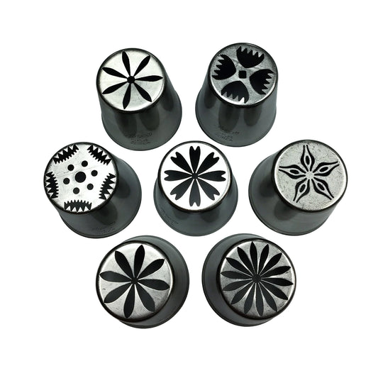 Seven metal Russian piping tips arranged on a white background, each showing a different flower cutout pattern on the tip opening.