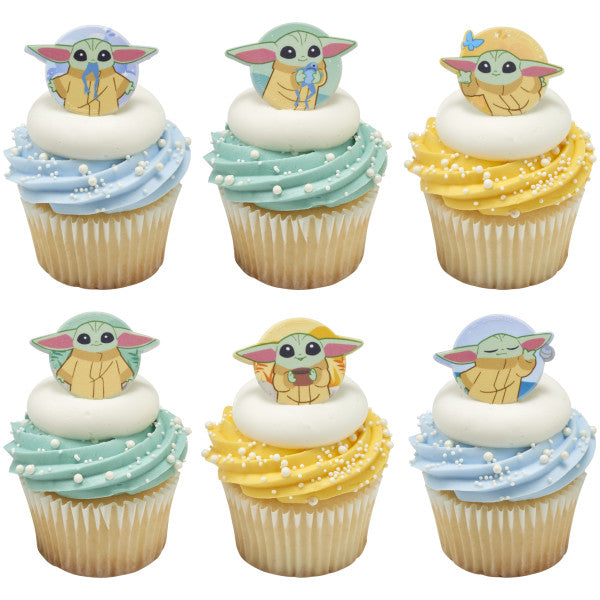 Six cupcakes with blue, mint, and yellow buttercream swirls topped with white pearl sprinkles and Grogu cupcake rings from The Mandalorian.