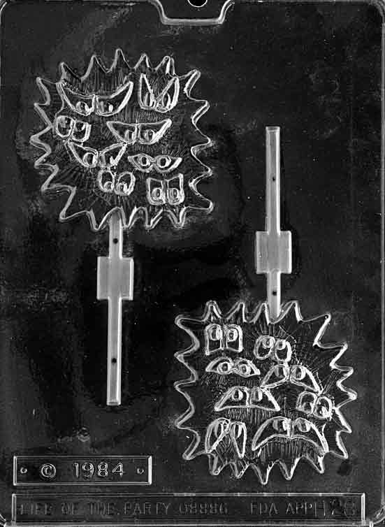 Clear two-cavity lollipop mold showing jagged starburst shapes filled with multiple scary eyes, each cavity aligned with a stick channel on a glossy plastic sheet.