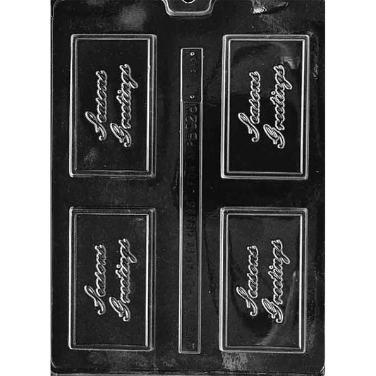 Clear plastic chocolate mold with four rectangular bar cavities, each embossed with “Season’s Greetings” in script inside a raised border frame; shown on a dark background.