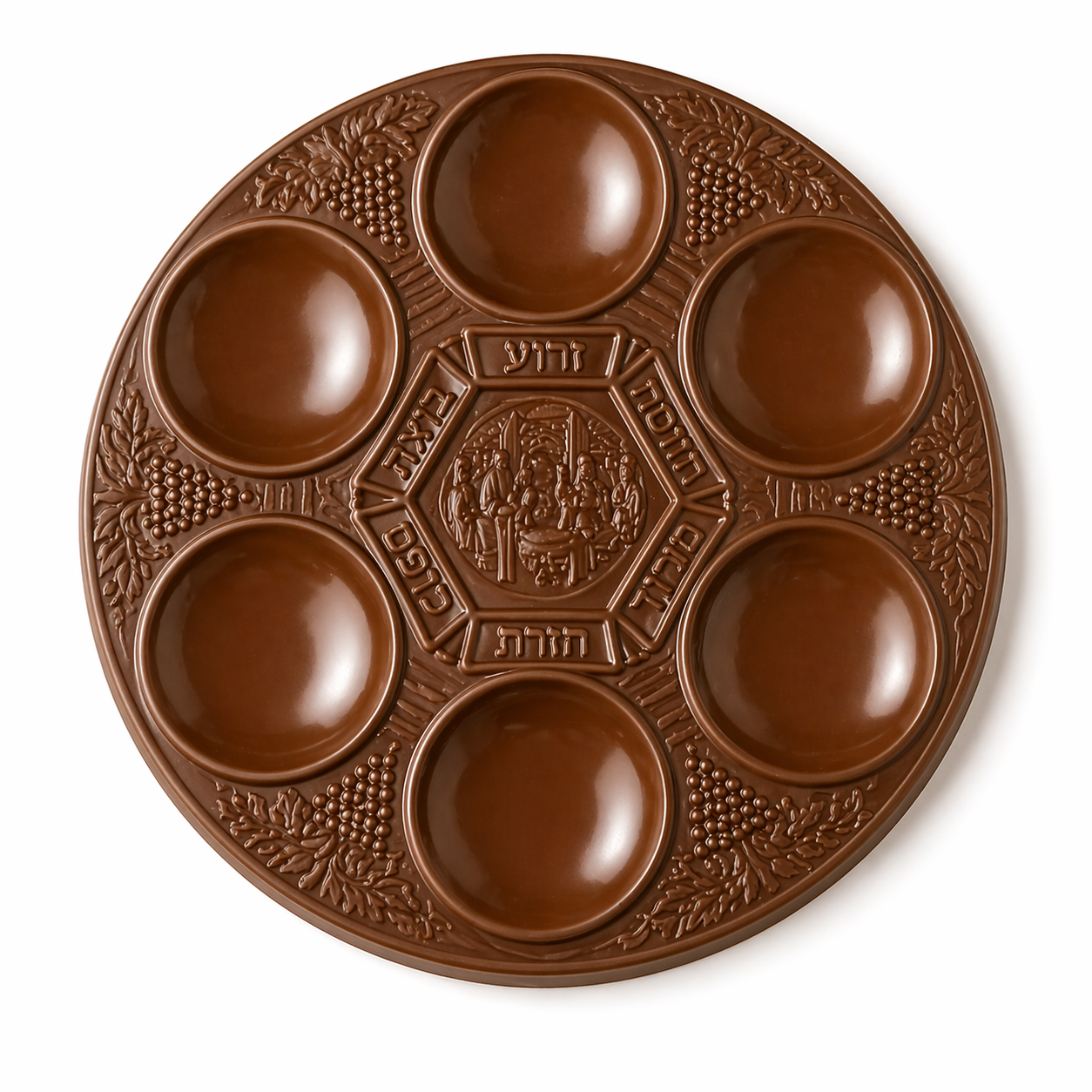 Round chocolate seder plate with six circular compartments arranged around the edge and a raised decorative center, featuring detailed embossed patterns on the surface.