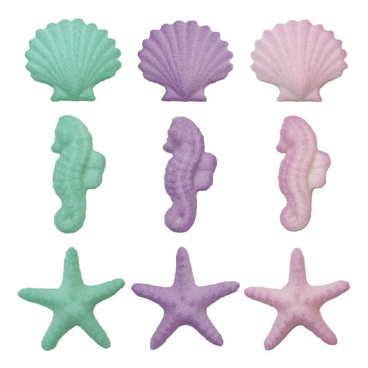 A variety of sugar decorations shaped like seahorses, starfish, and seashells, in shades of green, pink, and purple.