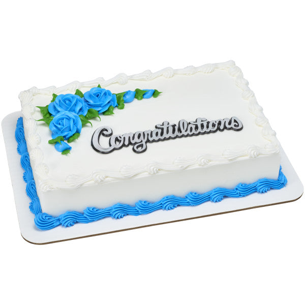Rectangular white sheet cake with blue rose decorations and “Congratulations” cake topper layon.