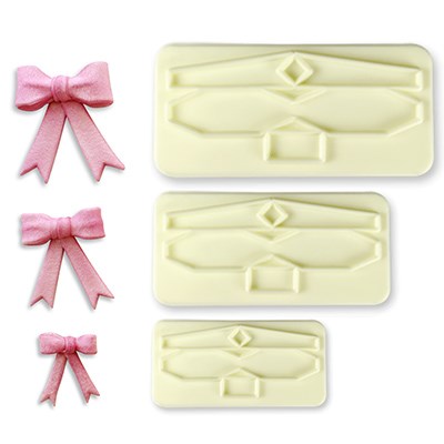 Three-piece bow cutter set with pink fondant bows beside each matching cutter size