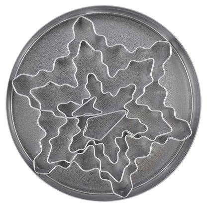 Nested snowflake cookie cutter set displayed inside a round tin container.