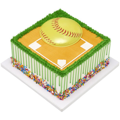 Square softball-themed cake with field design, green grass piping, and yellow softball Pop Top® centerpiece.