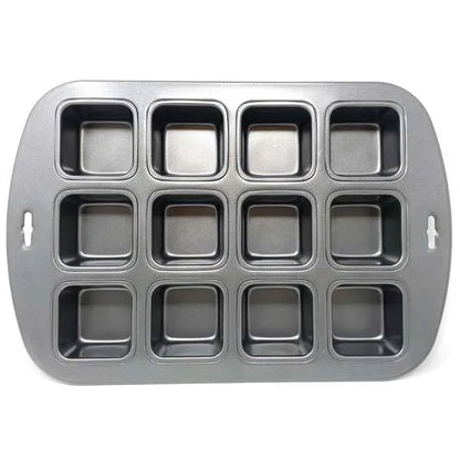 Non-stick metal baking pan with twelve square cavities, used for baking mini cakes or brownies.