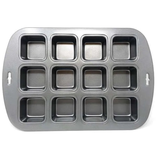 Non-stick metal baking pan with twelve square cavities, used for baking mini cakes or brownies.
