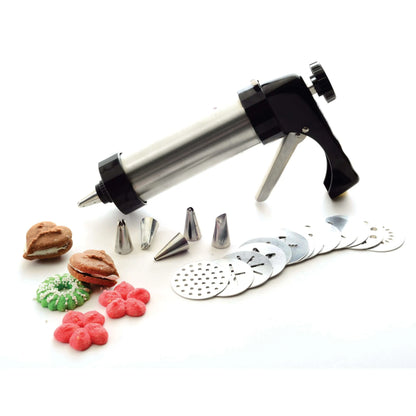Stainless steel cookie press gun with black handle, assorted decorating nozzles, disc plates, and colorful shaped cookies on white background.