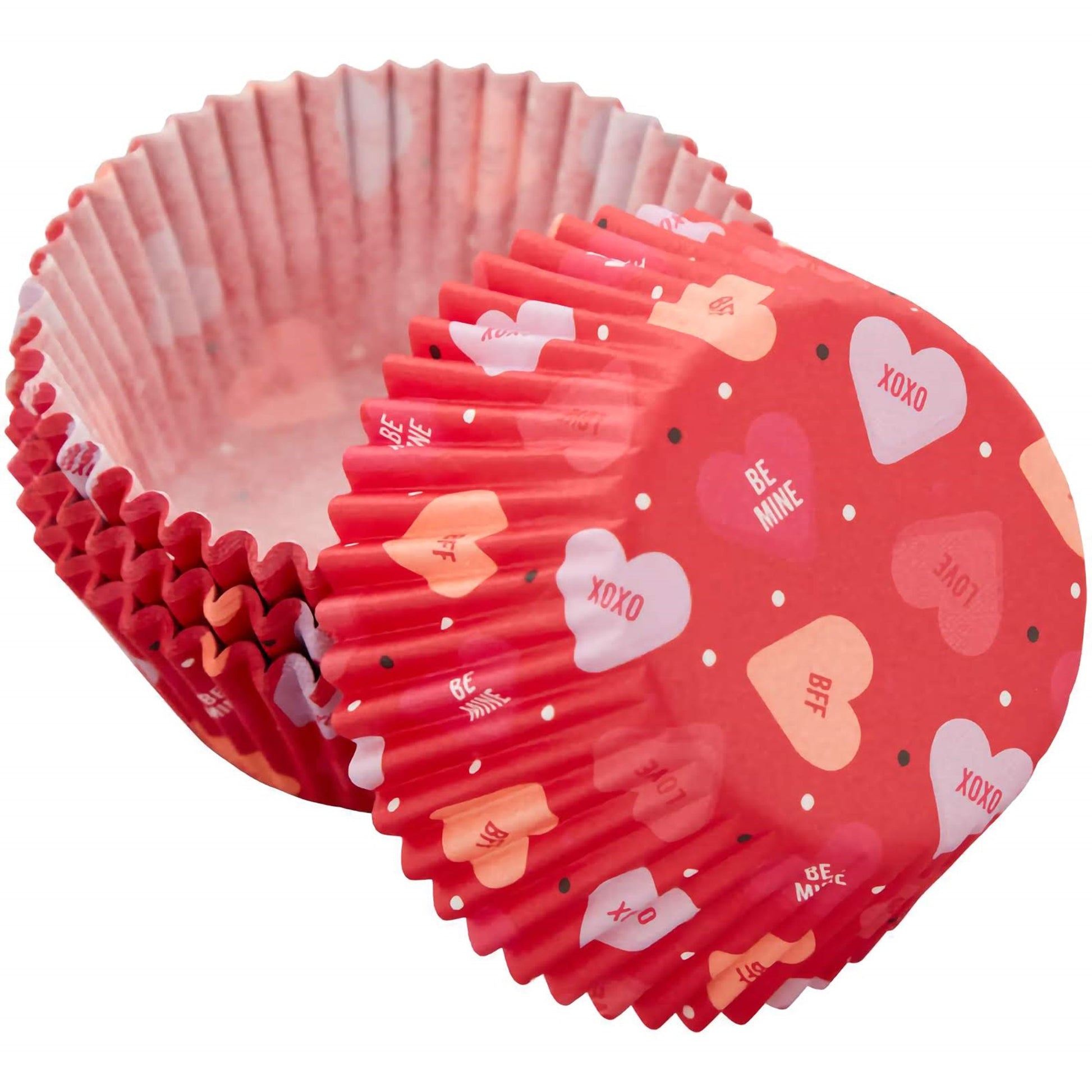 A stack of red cupcake baking cups with Valentine-themed phrases like "XOXO," "LOVE," "BFF," and "Be Mine" printed in white, along with white heart shapes on a red background.