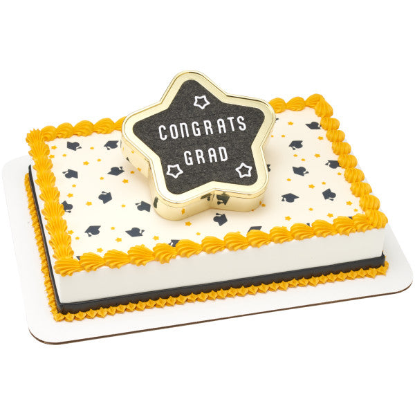 A rectangular graduation cake with gold and black star decorations, topped with the Star Grad Letter Board DecoSet displaying "CONGRATS GRAD"