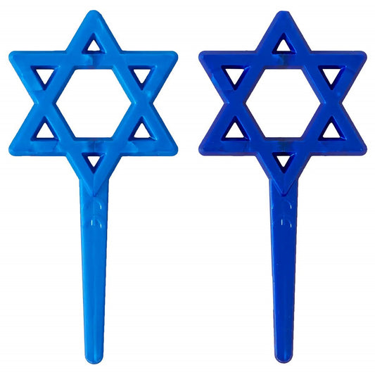 Two Star of David cupcake picks in light blue and dark blue plastic, each with a six-point star topper and a long pointed pick.