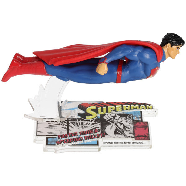 Close-up of Superman flying figurine with a comic-style base reading "Faster than a speeding bullet."