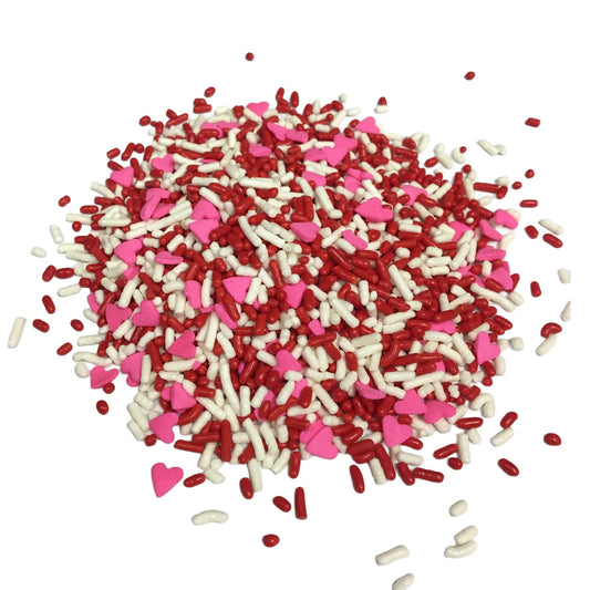 Pile of Valentine sprinkle mix with red and white jimmies and bright pink heart-shaped sprinkles scattered on a white background.