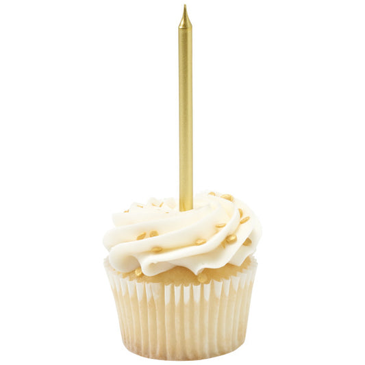 Vanilla cupcake in a white paper liner with a white frosting swirl and gold sugar pearls, topped with one tall metallic gold candle standing straight up.