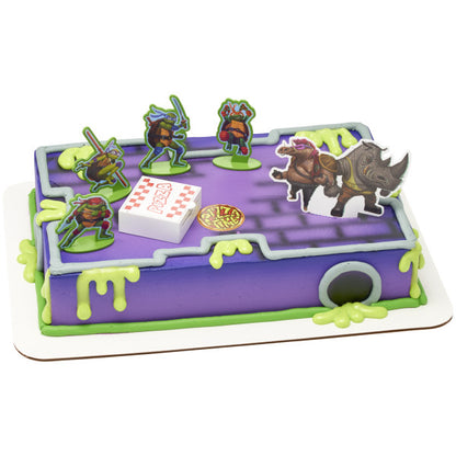 A rectangular cake decorated with the TMNT Pizza Power! DecoSet®, designed like a sewer battle scene.