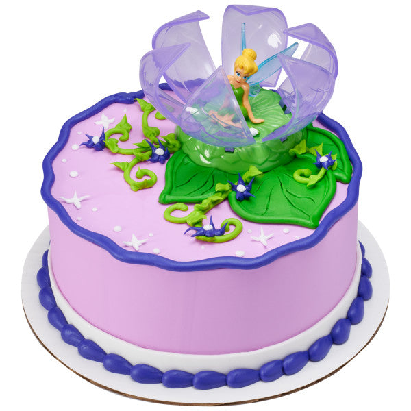 A round cake featuring the Tinker Bell DecoSet®, with magical star and flower decorations.