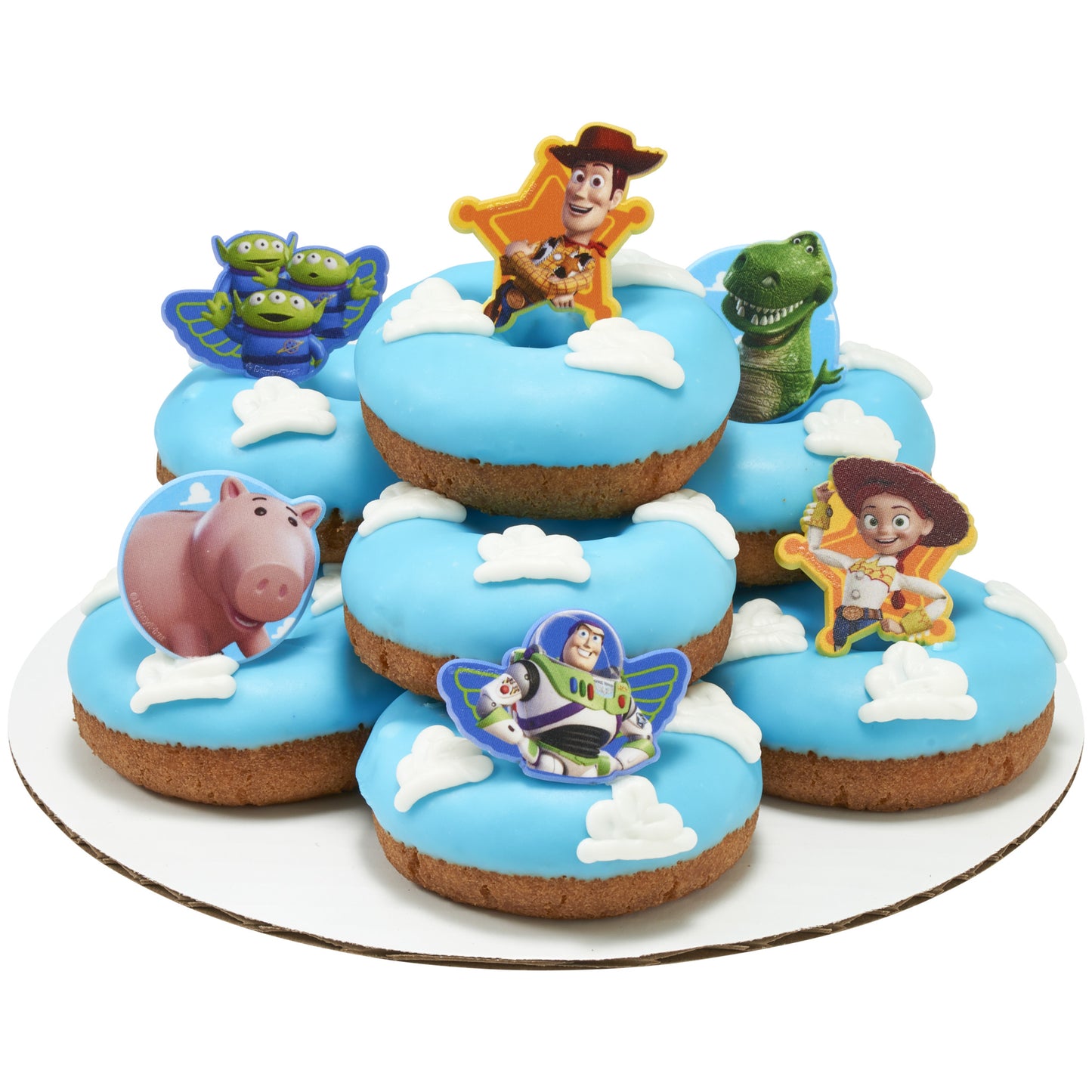 Blue frosted donuts decorated with white cloud shapes and topped with Toy Story cupcake rings featuring a cowboy, green dinosaur, piggy bank, and other characters.