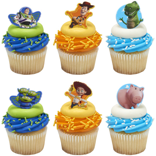 Vanilla cupcakes with colorful frosting swirls topped with Toy Story character cupcake rings, including a space ranger, cowboy, and green dinosaur.