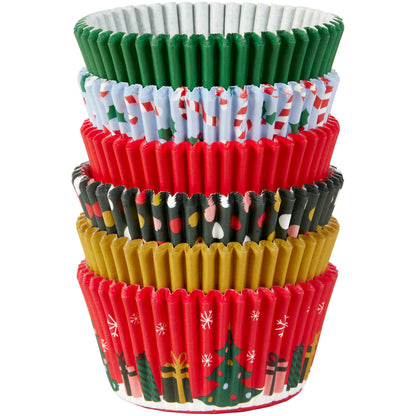 Stack of Wilton Christmas baking cups in six traditional holiday designs including Christmas trees, lights, and candy canes.