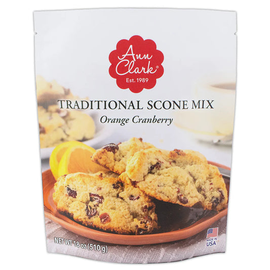 Front of Ann Clark Traditional Scone Mix Orange Cranberry package showing freshly baked golden scones with cranberries, orange slices, and a cup of tea.
