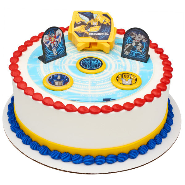 A round cake decorated with the Transformers™ Autobot Battle DecoSet®, showcasing a high-tech circuit board design and interactive elements.