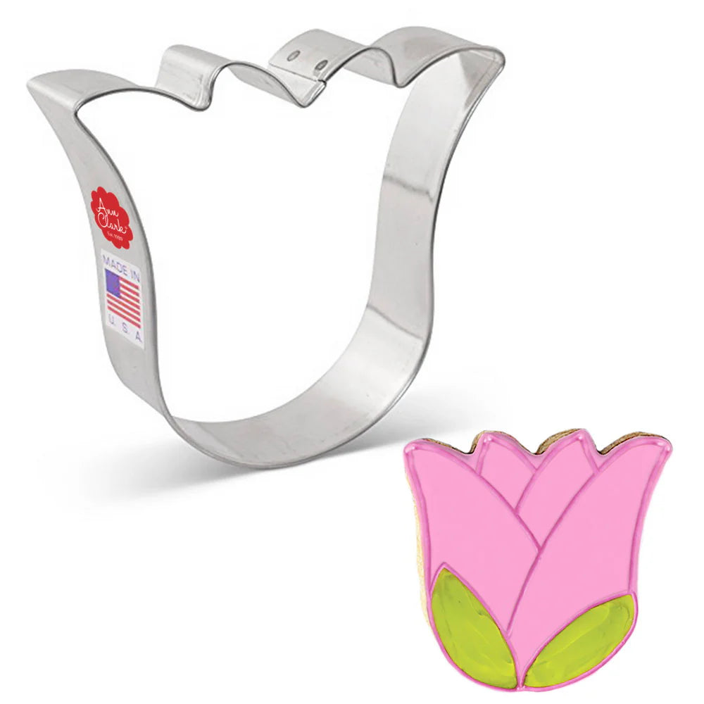 Tulip-shaped cookie cutter alongside a decorated pink tulip cookie.