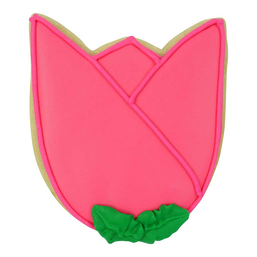 Decorated tulip-shaped cookie with bright pink icing and a green leaf, made using a tulip bloom cookie cutter.