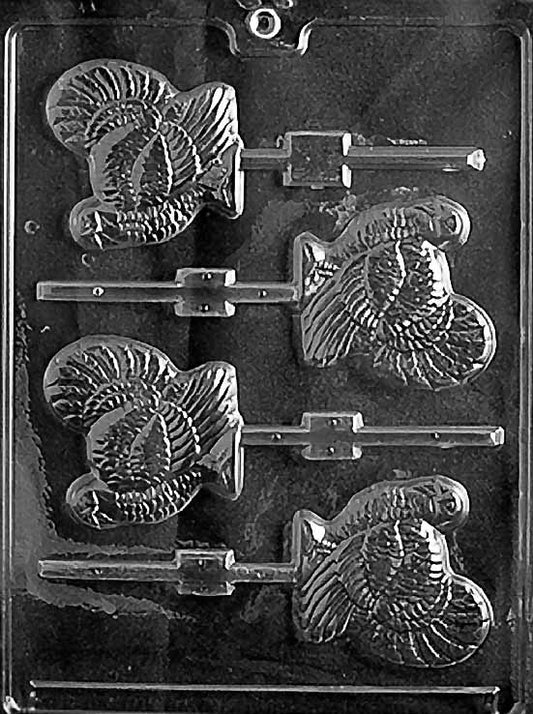Clear lollipop mold featuring four turkey shapes with layered feather detail and built-in stick channels, arranged vertically on a glossy plastic sheet.