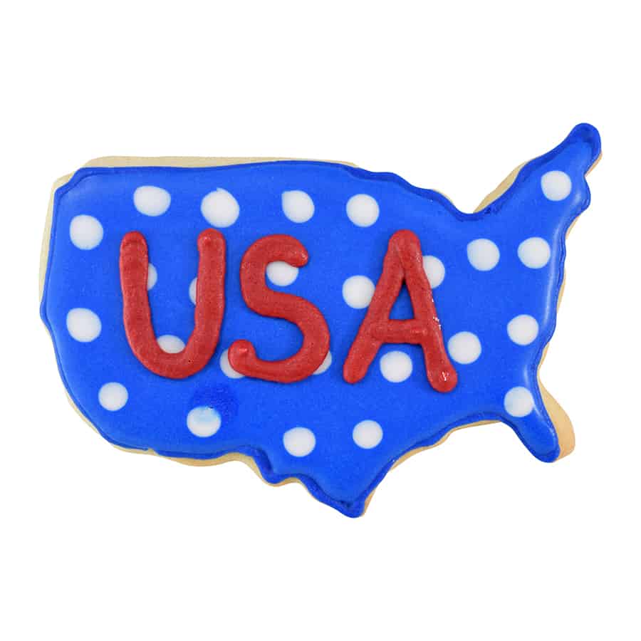 A USA map-shaped cookie decorated with blue icing, white polka dots, and the letters "USA" in red, made using the USA Map Cookie Cutter.