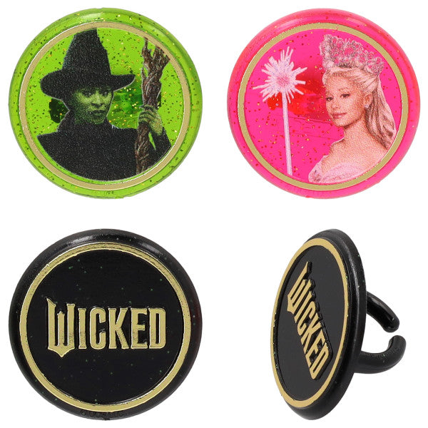 Set of three Wicked-themed cupcake rings on white background: one neon green ring with a silhouette-style green witch portrait, one bright pink ring with a sparkling wand-holding princess portrait, and one black ring with gold “WICKED” logo; all round with subtle glitter.