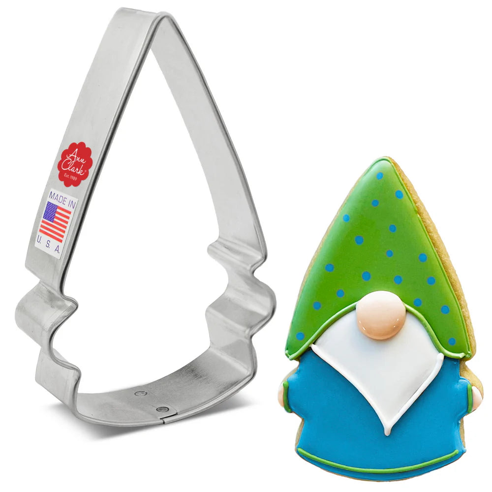 Gnome cookie cutter next to a decorated gnome cookie with a green polka-dot hat, white beard, and blue outfit.