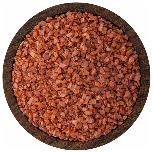 Top view of a round bowl filled with small-grain red Hawaiian-style sea salt crystals in earthy brick-red tones.